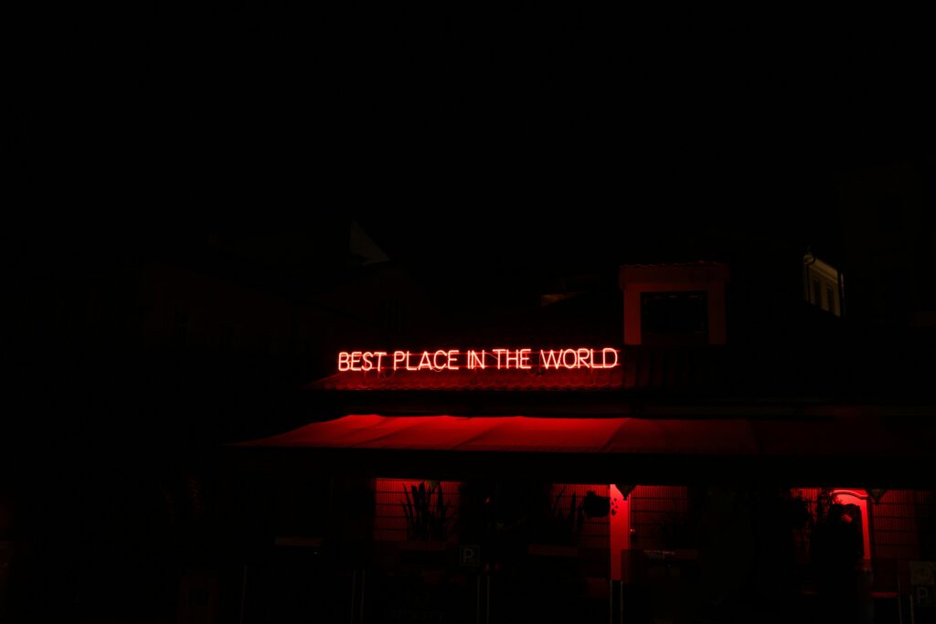 A captivating red neon sign illuminating a building facade at night, creating a vibrant and moody atmosphere.